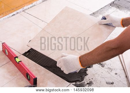 Tiler installing ceramic tiles on a floor