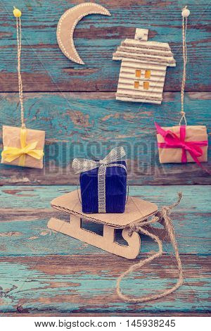Christmas decorations with sleigh and gifts on wooden boards painted in blue.