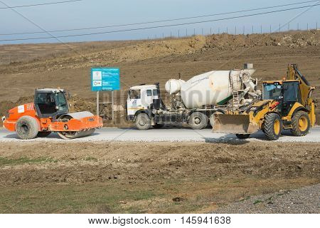 Taman, Russia - March 8, 2016: Ice Rink, Cement Mixer And Excavator Are On The Road Leading To The B