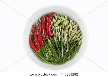 Garlic chives and red hot chili pepper in bowl on white background