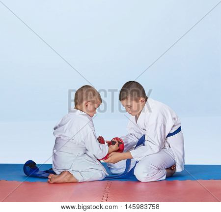 Athlete helps his brother to put on mitts