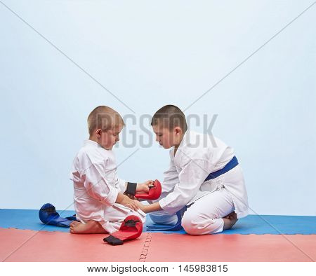 Two karate athlete to dress overlays on hands