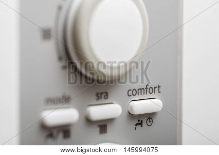 The comfort setup button on control panel of DHW or central heating.