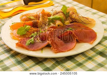 Trio Of Smoked Fish With Basil On A White Plate In The Region Of Mistretta In Northern Sicily