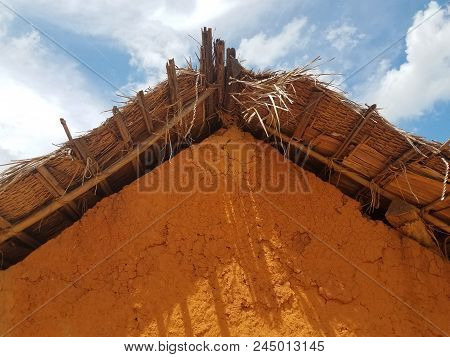 Brown And Red Side Of Adobe Or Clay Building With Straw Roof