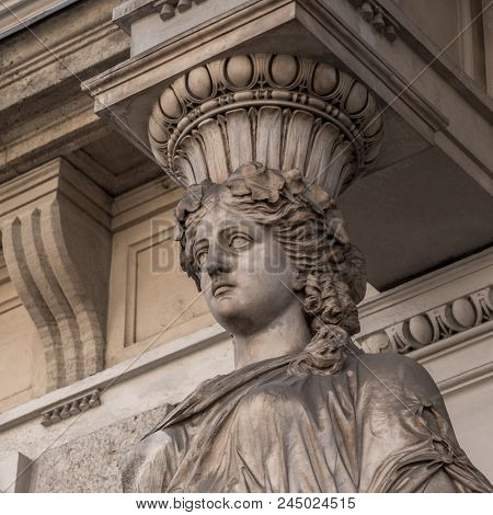 Caryatid stained sculpture adorns the old house facade on the street of Budapest