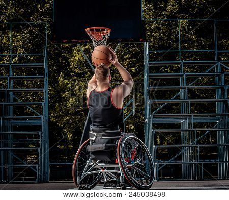 Cripple Basketball Player In A Wheelchair Plays On An Open Gaming Ground.