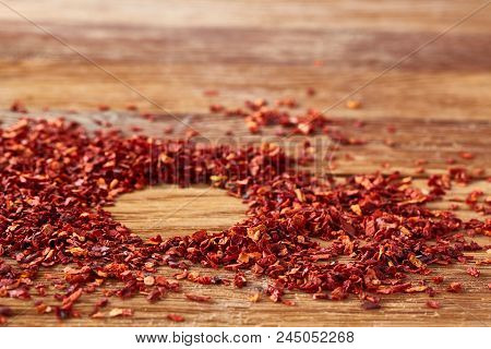 Circle Framing Made Of Dried Red Hot Chilly Flakes On Rustic Wooden Background, Top View, Close-up, 