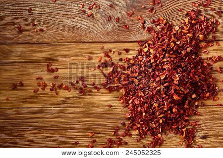 Dried Red Hot Chilly Flakes On Rustic Wooden Background, Top View, Close-up, Macro, Selective Focus.
