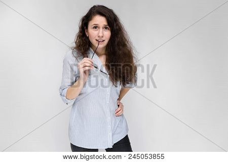 Happy Young Girl In A Light Blouse And Dark Pants. The Girl Refuses To Take Glasses.