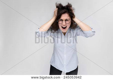 Young Girl With Glasses On A Gray Background. Portrait Of A Young Beautiful Girl. A Charming Girl In