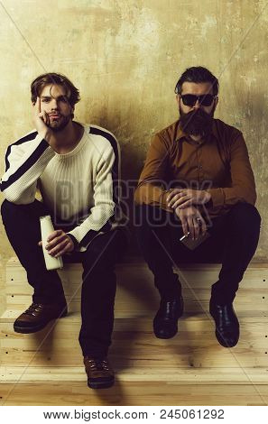 Healthy Lifestyle. Friendship, Convive. Two Friends In Casual Wear Sitting With Drinks On Wooden Sta