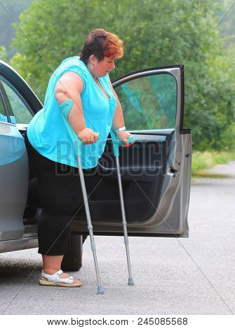 Disabled woman upgoing from a car. Transportation and travel for handicapped people.