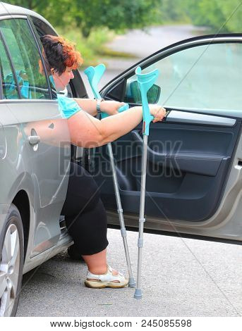 Disabled woman upgoing from a car. Transportation and travel for handicapped people.