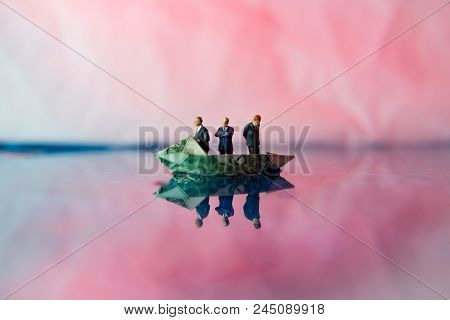 Miniature Figurine Businessmen Ride On Dollar Bill Origami Yacht