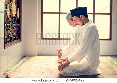 Muslim men praying in Tashahhud posture