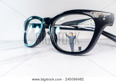 Optician Eyeglasses Being Cleaned By Tiny Figurine Symbolizing Clear Vision