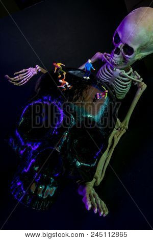 Roller Skating And Skateboarding Figurines Evade Giant Skeleton