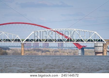 A Freight Train Is Driving Across A Bridge Across The River