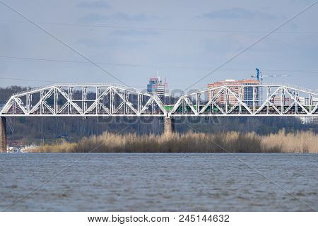 A Freight Train Is Driving Across A Bridge Across The River