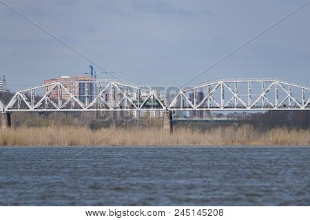 The Train Travels Along The Railway Bridge Across The River