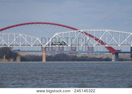 The Train Travels Along The Railway Bridge Across The River