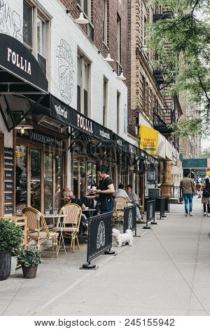 New York, Usa - May 29, 2018: Waitress Bring Food To The People Sitting At The Outdoor Tables Of The