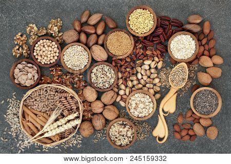 Food with high fibre content for a healthy diet with whole wheat bread, whole grain pasta, nuts, seeds, legumes, grains and cereals. High in antioxidants, anthocyanins, vitamins & omega 3 fatty acids.