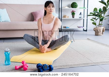 Beautiful Young Woman Practicing Yoga In Bound Angle Pose At Home