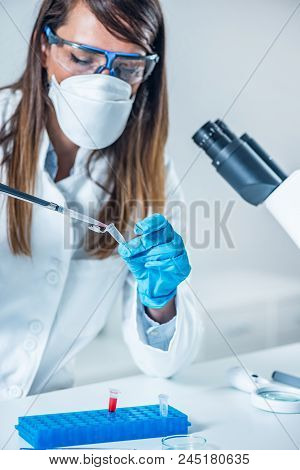Forensic Science Expert Examining Evidence, Looking For Traces Of Dna
