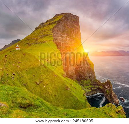 Shot of beautiful sunrise over Kalsoy island and Kallur lighthouse, Faroe Islands