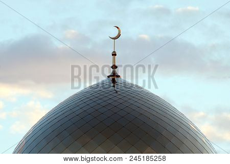 Minaret On The Blue Evening Of The Morning Sky With Clouds. The Symbol Of Islam Is A Golden Crescent