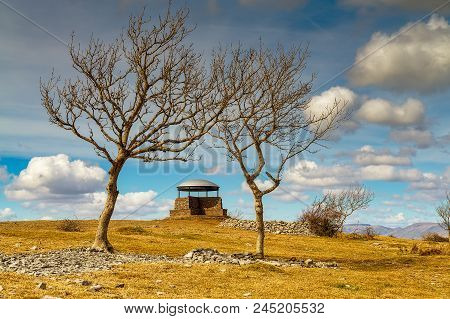 The Mushroom On Scout Scar, Kendal, Framed By Two Ash Trees. Landscape View.
