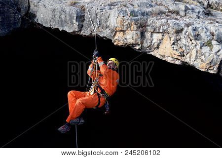 Speleologist ascending by a rope. Zaragoza Province, Aragon, Spain.