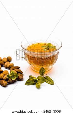 Beneficial And Essential Oil Of Badam Or Almonds With Its Beneficial Tea In A Transparent Cup Isolat