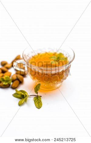 Beneficial And Essential Oil Of Badam Or Almonds With Its Beneficial Tea In A Transparent Cup Isolat