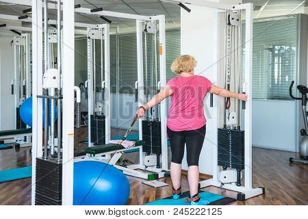 Backview Elderly Woman Doing Active, Special Exercises For Her Hands At The Hospital Rehabilitation 