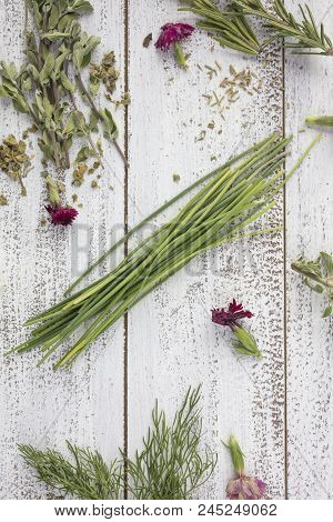 Tarragon, Rosemary, Chives, Sage, Marjoram And Dill Herbs On A Rustic Table Top With Edible Flowers
