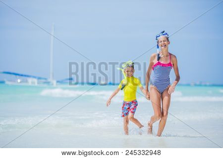 Brother And Sister Runing And Having Fun On The Beach During The Hot Summer Vacation Day.