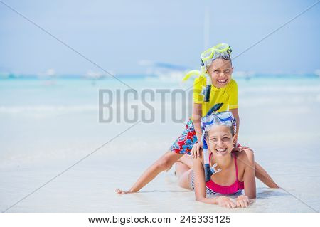 Brother And Sister Playing And Having Fun On The Beach During The Hot Summer Vacation Day.