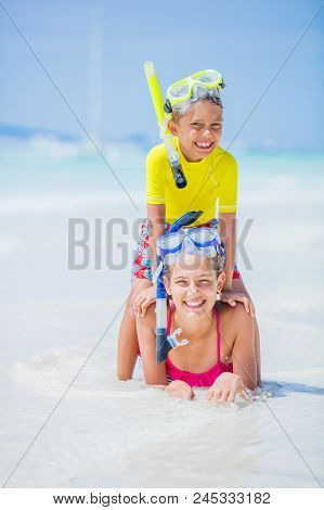 Brother And Sister Playing And Having Fun On The Beach During The Hot Summer Vacation Day.