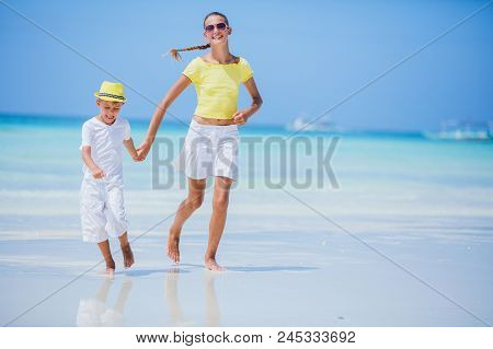 Brother And Sister Runing And Having Fun On The Beach During The Hot Summer Vacation Day.