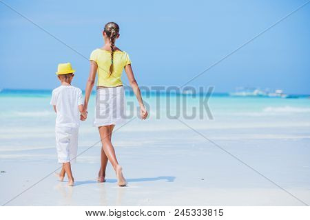 Brother And Sister Walking And Having Fun On The Beach During The Hot Summer Vacation Day.