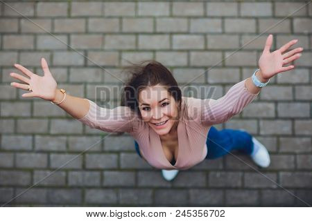 Young Smiling Teen Girl Looking At Camera. Shot From Above.