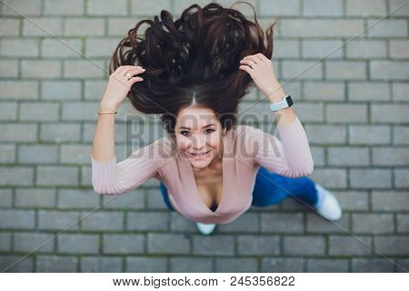 Young Smiling Teen Girl Looking At Camera. Shot From Above.