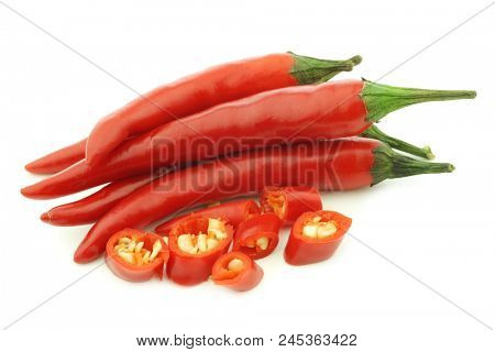 red rawit peppers (Capsicum annuum 'Bird's Eye') and a cut one on a white background