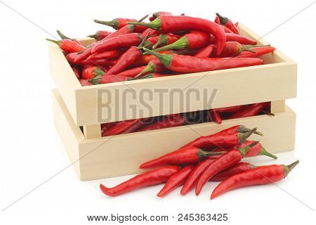 red rawit peppers  (Capsicum annuum 'Bird's Eye') in a wooden box on a white background