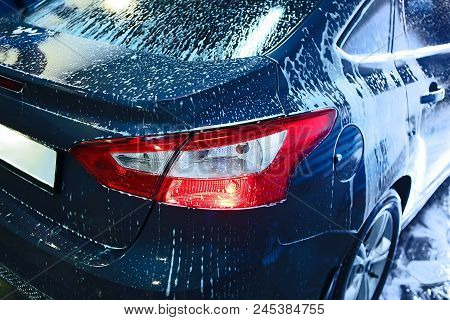 Blue Car Covered With Foam On Car Wash