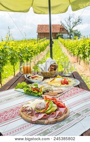 Brettljause, Traditional Cold Plate With Meat, Cheese, Fish, Vegetable, Bread And Drinks On Wooden T