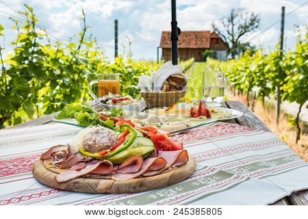 Brettljause, Traditional Cold Plate With Meat, Cheese, Fish, Vegetable, Bread And Drinks On Wooden T